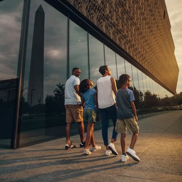 Family walking by the Smithsonian National Museum of African American History and Culture - Free museum on the National Mall in DC Family walking by the Smithsonian National Museum of African American History and Culture - Free museum on the National Mall in DC